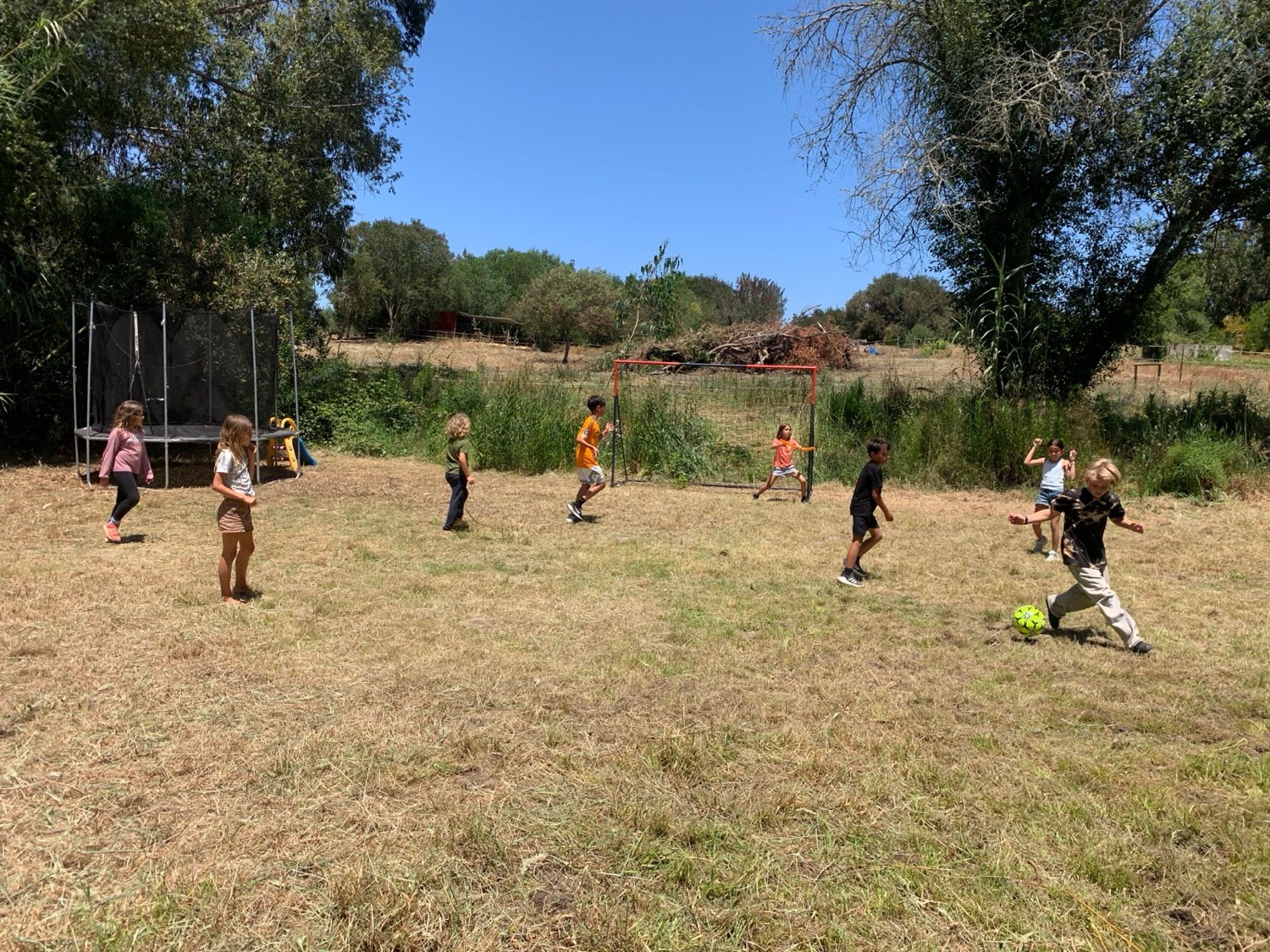 Children playing a game together on a wide grassy field