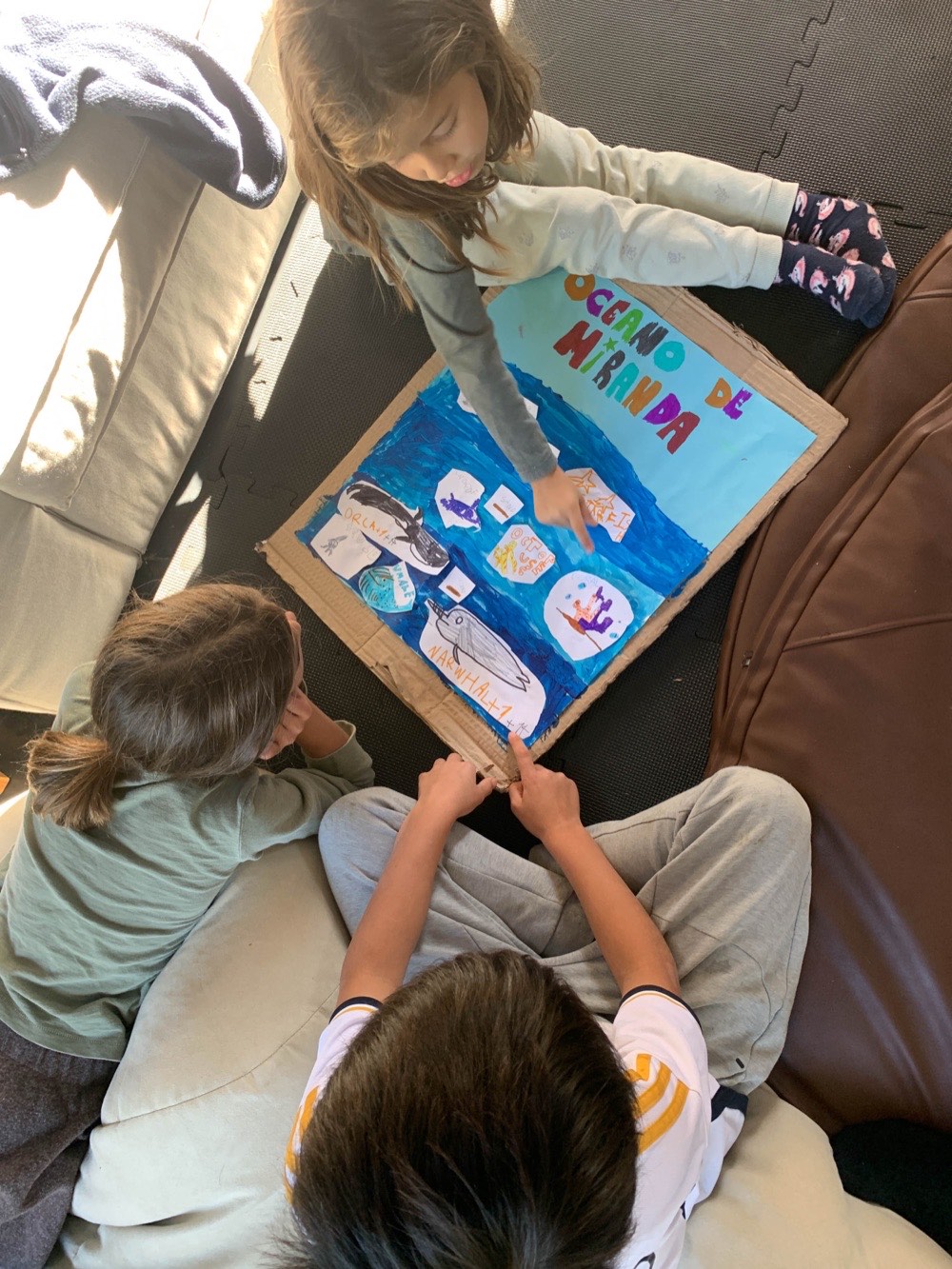 Children presenting a hand-made project board in the studio
